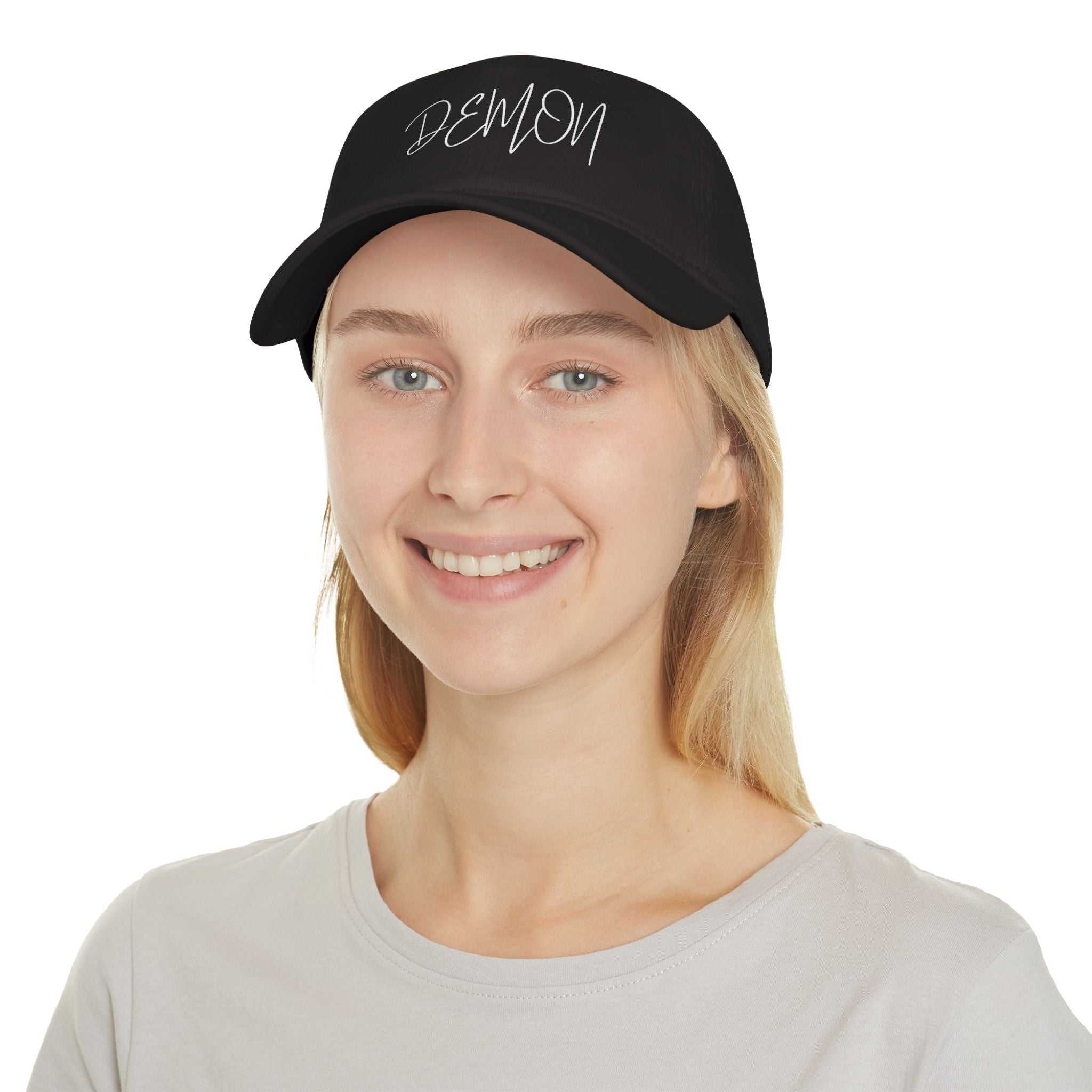 Black Demon Script Baseball Cap on smiling woman wearing gray shirt, low-profile cotton twill hat with adjustable Velcro strap.