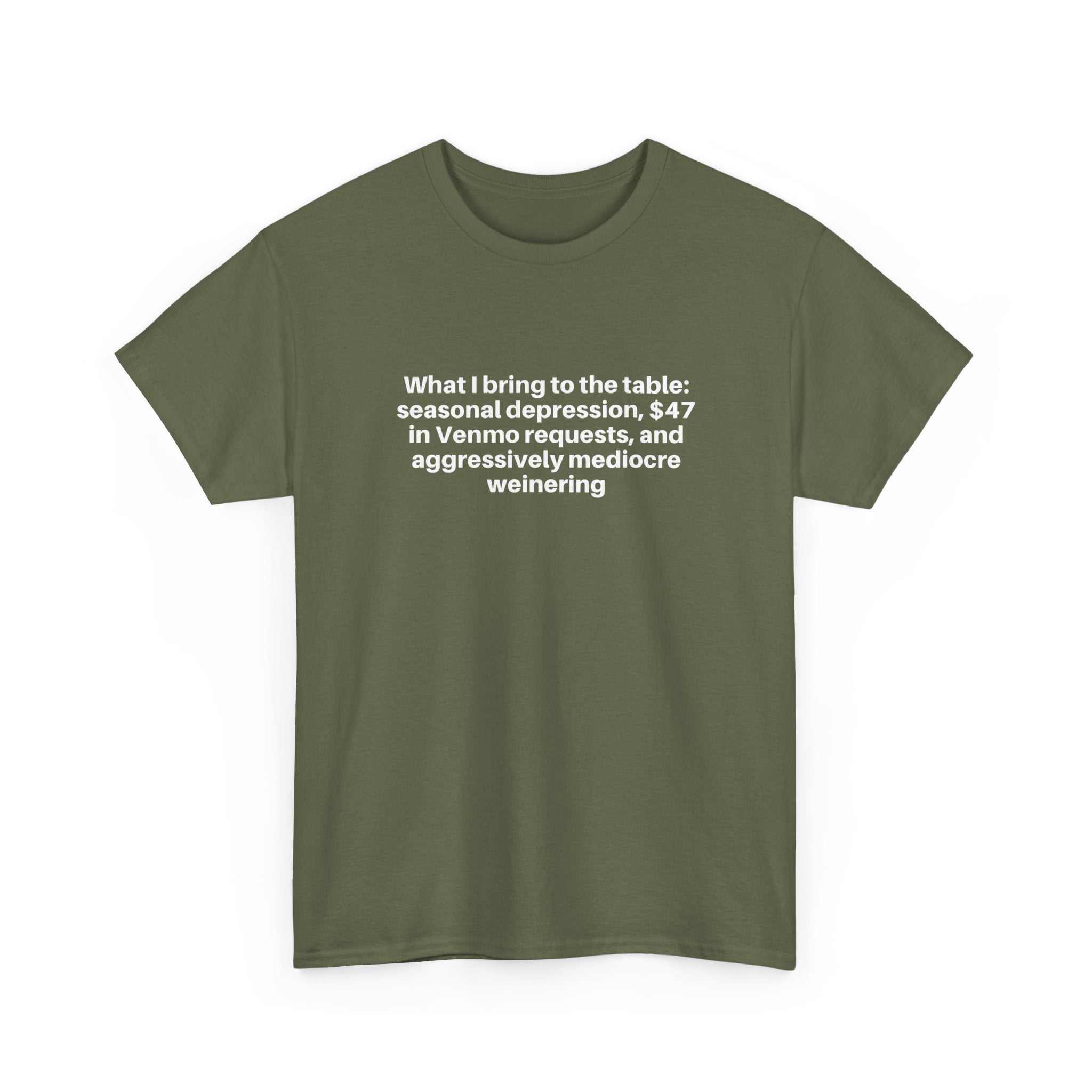 Green relaxed-fit t-shirt with white humorous text "What I bring to the table" printed on the chest, made of 100% cotton.